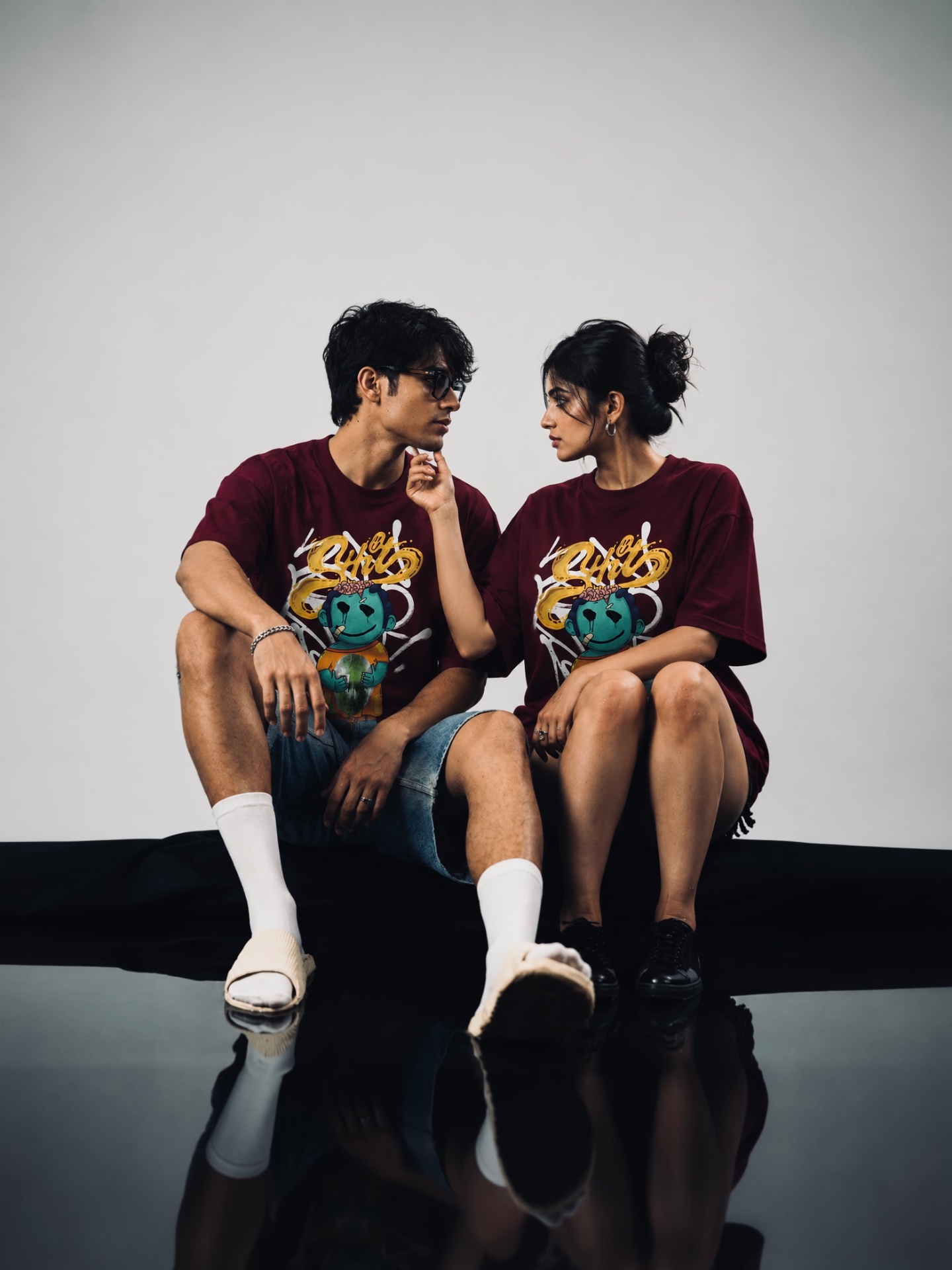 Couple wearing DANEEVA maroon graffiti oversized tees